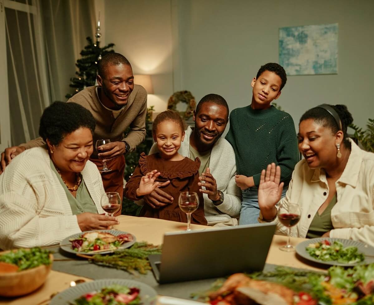 Family Enjoying Online Christmas Celebrations getty-images-ggsL7ou1nRg-unsplash Family Laughing and Looking at the Laptop with Christmas tree behind. Image from Unsplash.